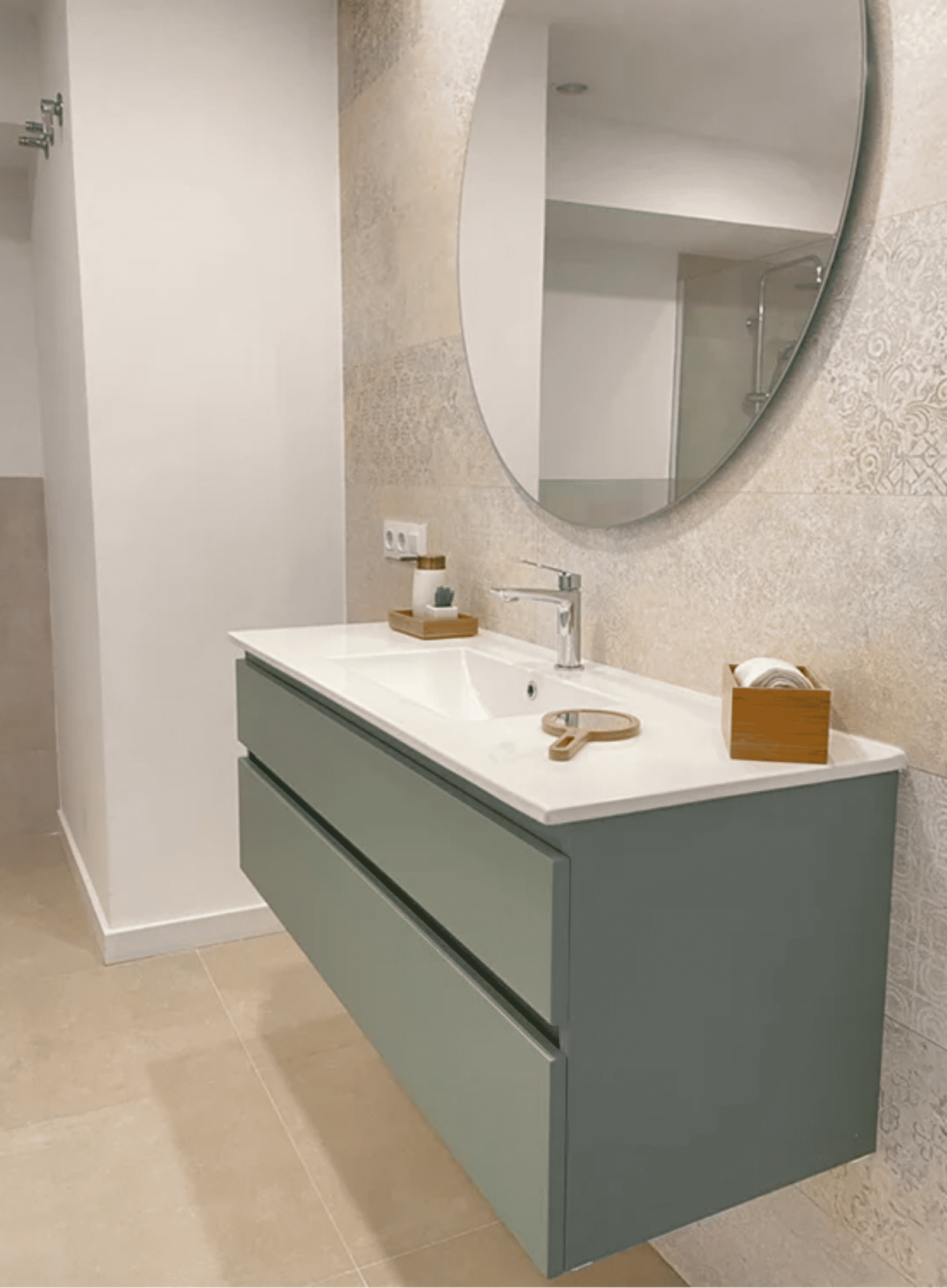 Mueble de baño suspendido en color verde menta con lavabo blanco y espejo redondo.