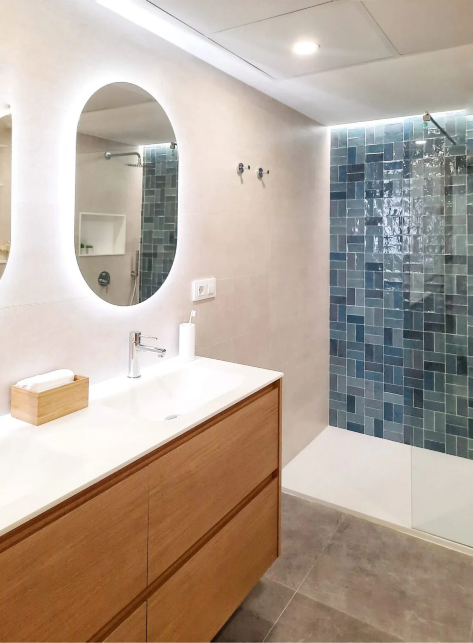 Detalle de mueble de baño en madera de roble con toallero lateral y espejo con iluminación.